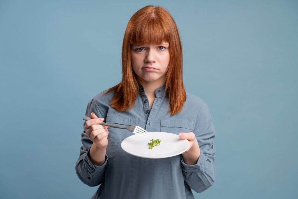 Mujer descontenta sosteniendo un plato con comida